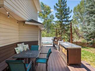 Enjoy outdoor living at its finest on this spacious deck, complete with a dining set, a built-in grill station, and a relaxing hot tub.