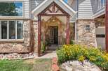 Discover this charming home featuring a rustic stone facade and a welcoming covered entryway with log accents.