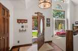 Step into a grand entryway featuring a beautiful wooden door with an oval glass insert, welcoming you into a home filled with natural light.