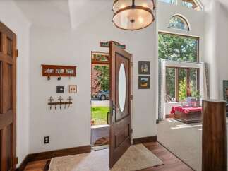 Step into a grand entryway featuring a beautiful wooden door with an oval glass insert, welcoming you into a home filled with natural light.