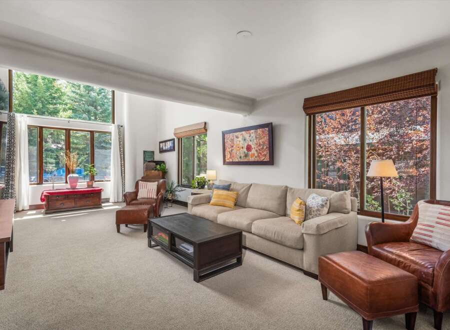 Experience the ultimate in relaxation and style in this inviting living room, featuring a spacious sectional sofa perfect for gatherings and plush leather armchairs for individual comfort.