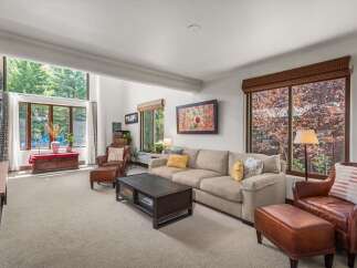 Experience the ultimate in relaxation and style in this inviting living room, featuring a spacious sectional sofa perfect for gatherings and plush leather armchairs for individual comfort.