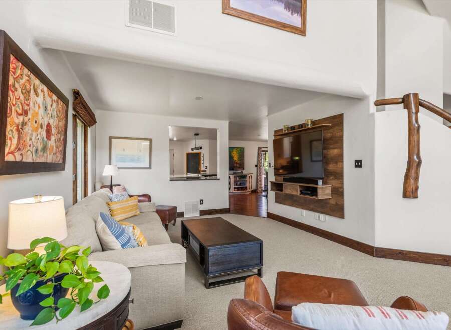 This spacious living room features a large, comfortable sectional sofa adorned with decorative pillows, perfect for relaxing.