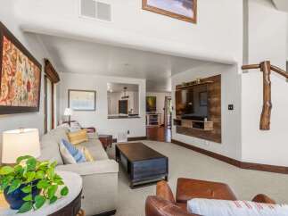 This spacious living room features a large, comfortable sectional sofa adorned with decorative pillows, perfect for relaxing.