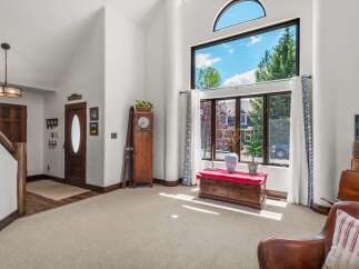 Step into this inviting living space featuring a grand arched window that floods the room with natural light and offers picturesque views.