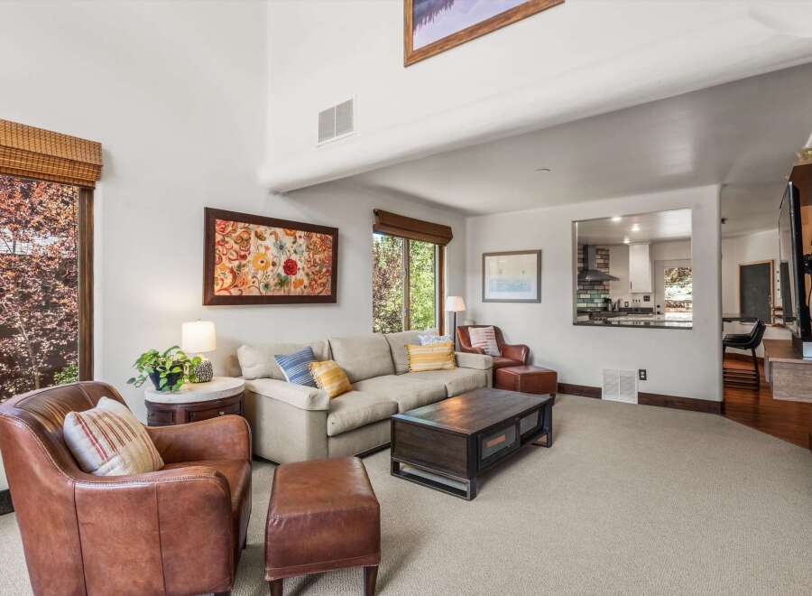 Experience ultimate comfort in this inviting living room, featuring plush leather armchairs and a spacious sectional sofa perfect for relaxation.