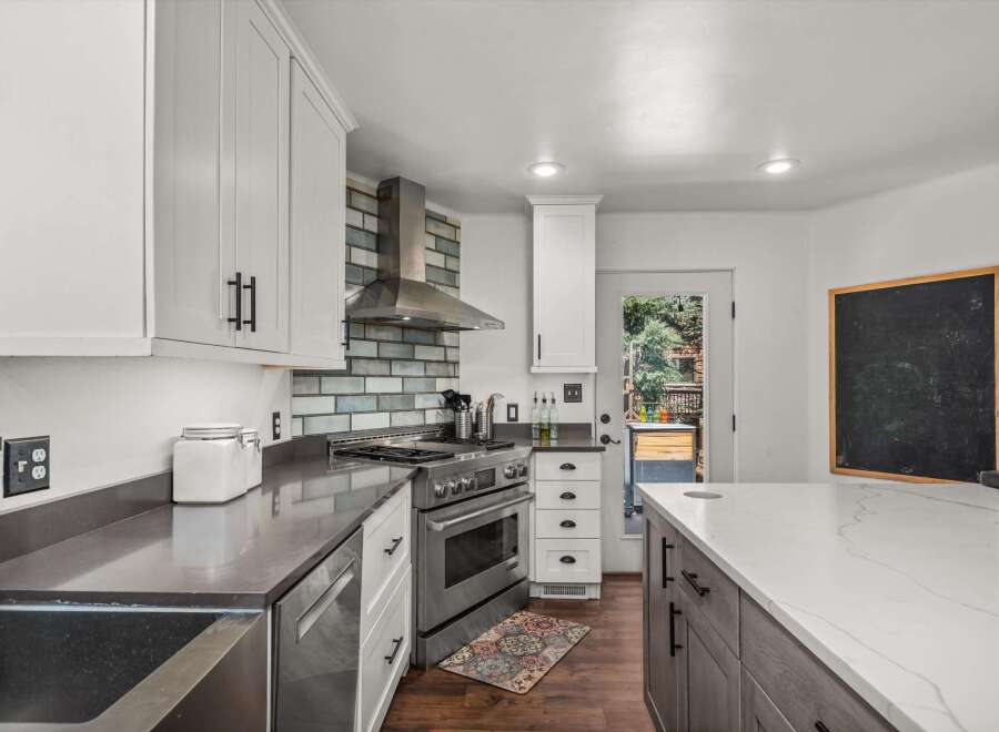 Experience culinary excellence in this stunning modern kitchen, featuring sleek white cabinetry and a striking subway tile backsplash.