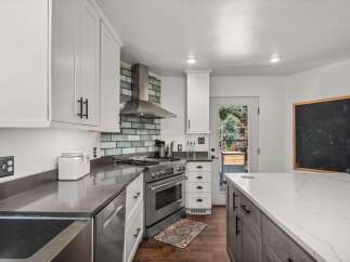 Experience culinary excellence in this stunning modern kitchen, featuring sleek white cabinetry and a striking subway tile backsplash.