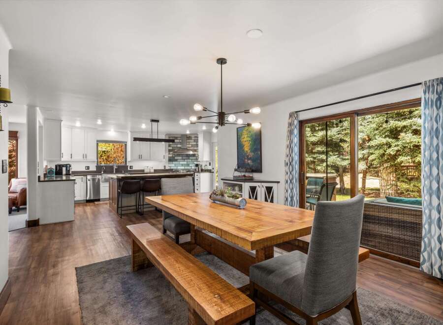 Experience seamless indoor-outdoor living in this beautifully appointed dining area, featuring a rustic wooden table and bench set perfect for gatherings.