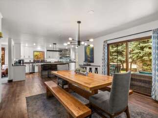 Experience seamless indoor-outdoor living in this beautifully appointed dining area, featuring a rustic wooden table and bench set perfect for gatherings.