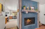 Cozy up by the rustic stone fireplace, featuring a natural wood mantel adorned with charming decor.