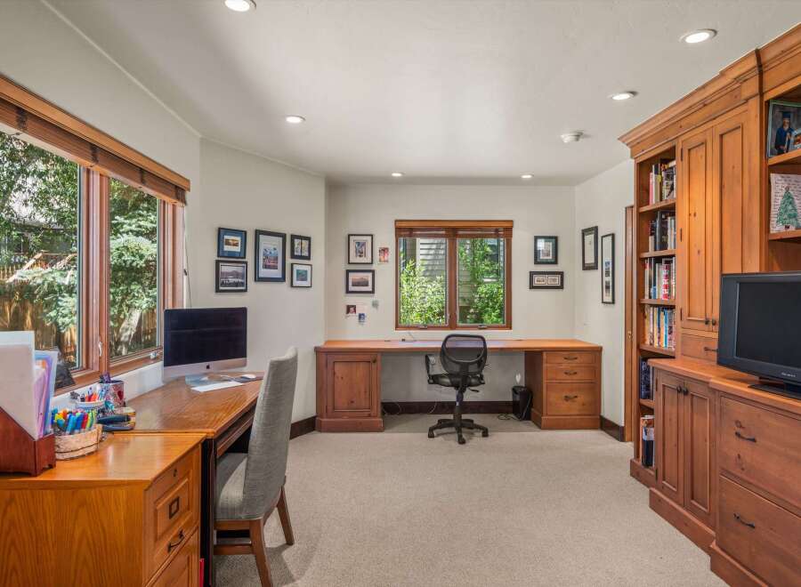 This home office features a spacious built-in wooden desk with ample storage, perfect for productivity.