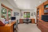 This home office features a spacious built-in wooden desk with ample storage, perfect for productivity.