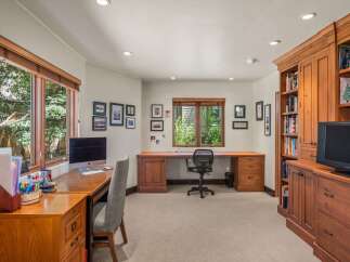 This home office features a spacious built-in wooden desk with ample storage, perfect for productivity.