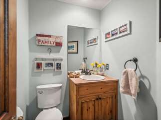 This charming bathroom features a rustic wooden vanity with a stone countertop, complementing the light blue walls.