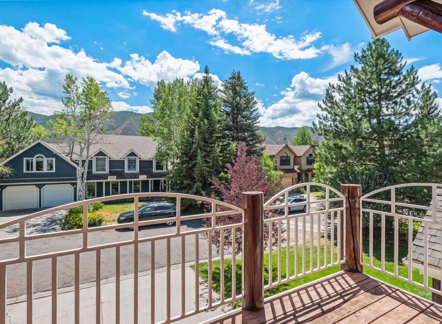 Enjoy stunning mountain views from this beautiful home, featuring a spacious deck with a white railing perfect for outdoor relaxation.
