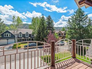 Enjoy stunning mountain views from this beautiful home, featuring a spacious deck with a white railing perfect for outdoor relaxation.