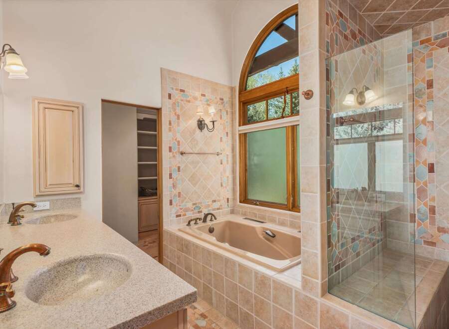 Indulge in luxury in this stunning bathroom featuring a spacious soaking tub and a separate glass-enclosed shower.