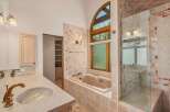 Indulge in luxury in this stunning bathroom featuring a spacious soaking tub and a separate glass-enclosed shower.