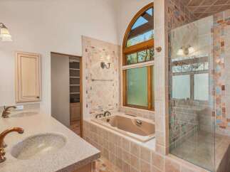 Indulge in luxury in this stunning bathroom featuring a spacious soaking tub and a separate glass-enclosed shower.