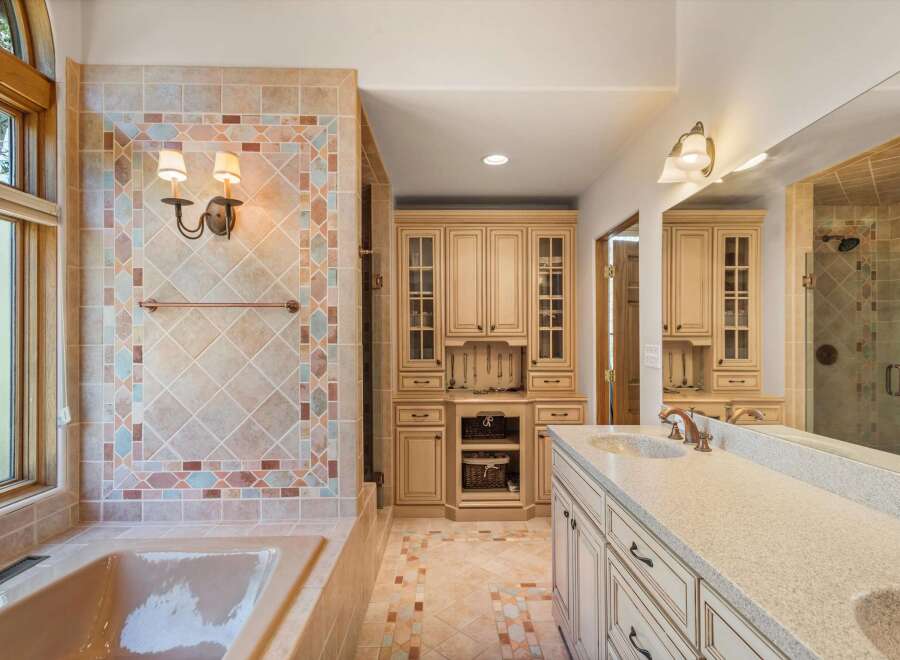 Indulge in luxury in this stunning bathroom featuring a spacious soaking tub and a beautifully tiled shower.