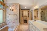 Indulge in luxury in this stunning bathroom featuring a spacious soaking tub and a beautifully tiled shower.