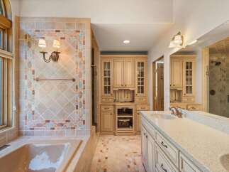 Indulge in luxury in this stunning bathroom featuring a spacious soaking tub and a beautifully tiled shower.