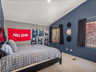 This unique bedroom features a striking design with a bold red 'FULL SEND' flag and several sports jerseys displayed as decor.