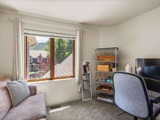 This cozy room features a comfortable sofa with striped pillows, perfect for relaxing.