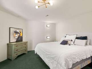 Discover this charming bedroom featuring a comfortable king-size bed adorned with plush pillows and a crisp white duvet.