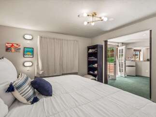 This charming bedroom offers a cozy retreat with a comfortable bed adorned with decorative pillows.
