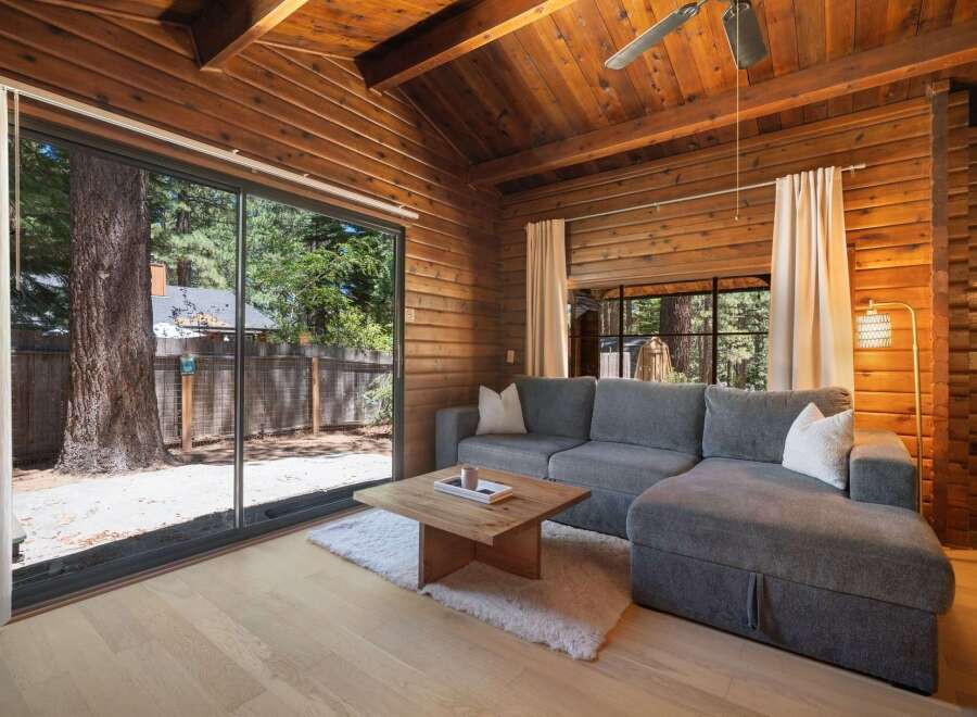 Experience rustic charm in this wood-paneled living room, featuring a spacious sectional sofa perfect for relaxation.