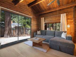 Experience rustic charm in this wood-paneled living room, featuring a spacious sectional sofa perfect for relaxation.