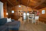 Experience rustic charm in this beautifully appointed cabin, featuring a spacious living area with a comfortable sectional sofa and a modern kitchen with a breakfast bar.