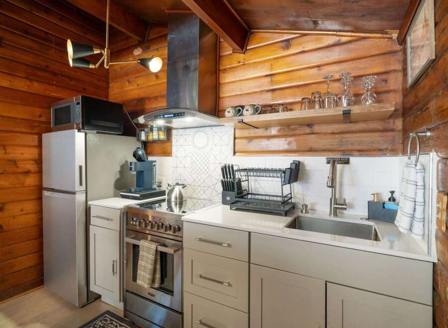 This charming kitchen features a modern stainless steel refrigerator and a sleek stovetop, perfect for preparing meals.