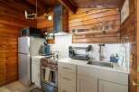 This charming kitchen features a modern stainless steel refrigerator and a sleek stovetop, perfect for preparing meals.