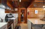 Experience rustic charm in this cozy kitchen featuring warm wood paneling and a modern aesthetic.