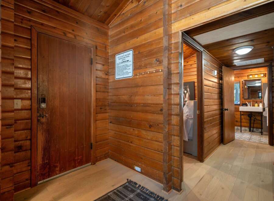 Step into a rustic cabin retreat featuring warm wood paneling throughout and a charming entryway.