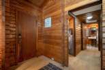 Step into a rustic cabin retreat featuring warm wood paneling throughout and a charming entryway.