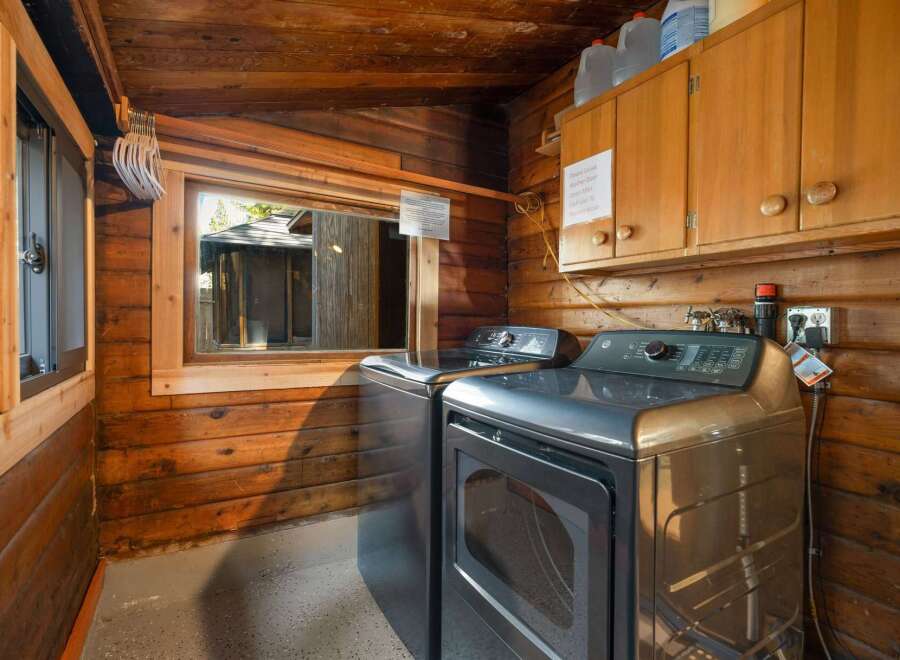 This rustic laundry room features a stacked washer and dryer set, perfect for maximizing space in a cabin or vacation home.