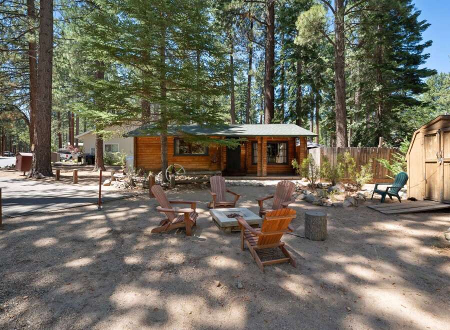 Escape to this charming log cabin nestled amongst tall pine trees, offering a serene retreat.