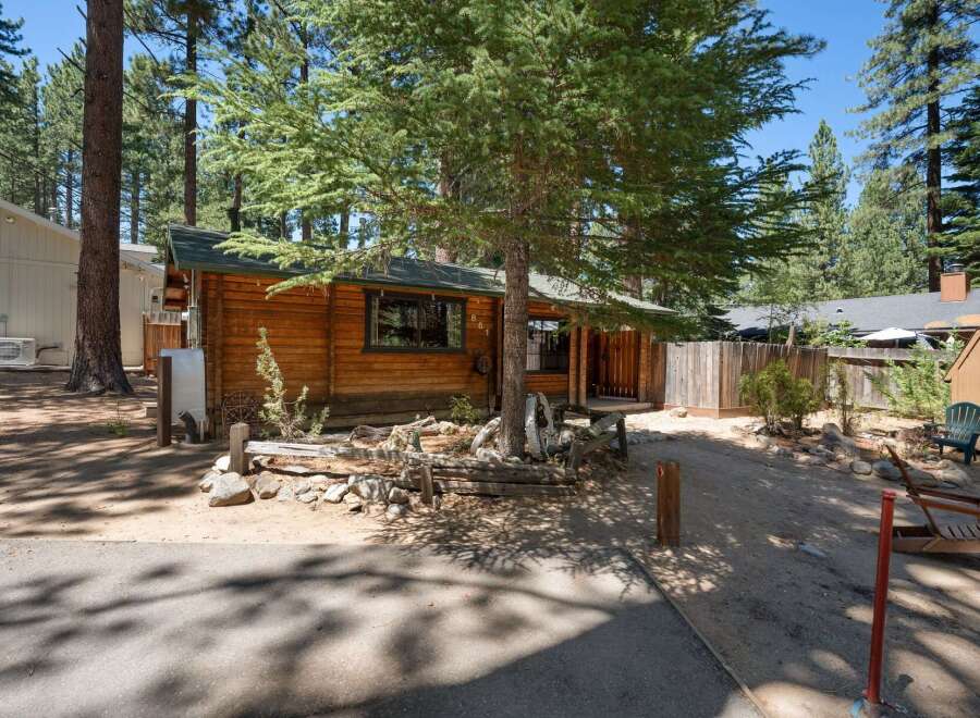 Charming log cabin nestled among tall pine trees, offering a rustic retreat.