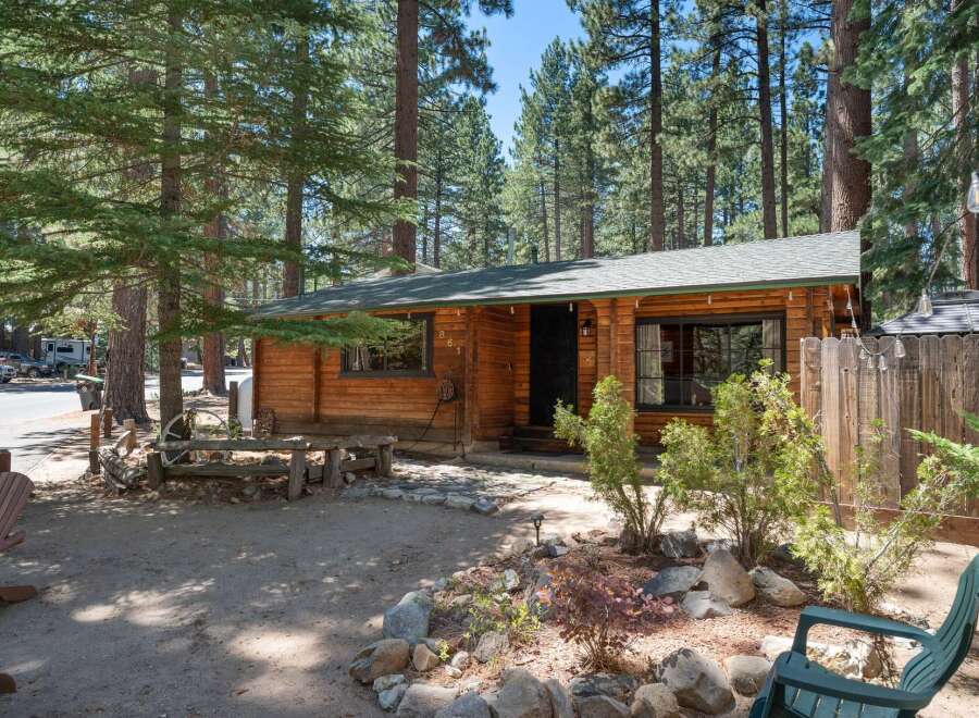 Charming log cabin nestled among tall pine trees, offering a serene mountain getaway.