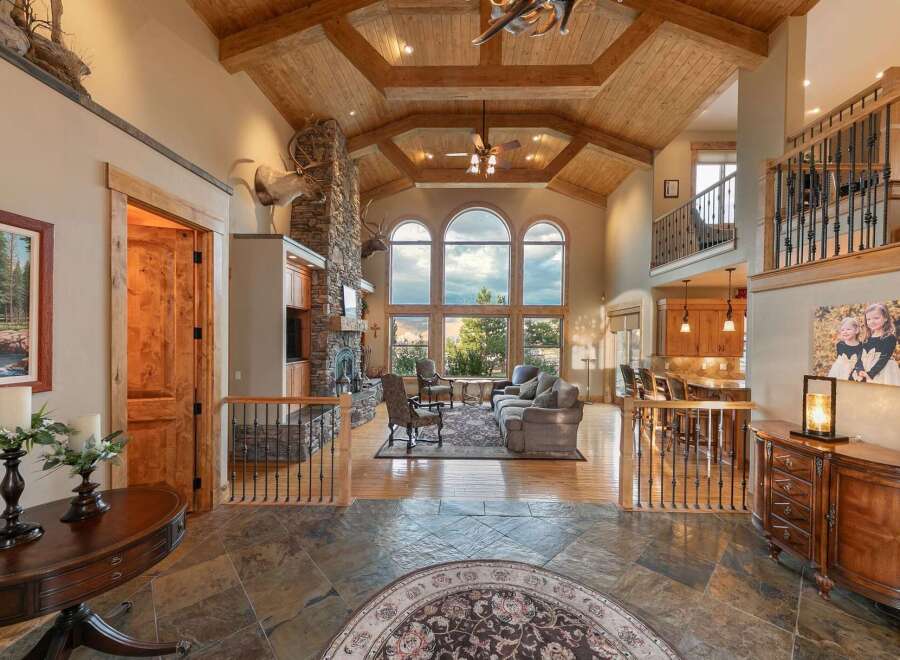 Experience luxury living in this grand lodge-style home featuring a soaring vaulted ceiling with exposed beams and a magnificent stone fireplace.