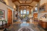 Experience luxury living in this grand lodge-style home featuring a soaring vaulted ceiling with exposed beams and a magnificent stone fireplace.