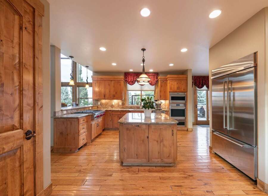 Experience luxury in this spacious kitchen featuring custom wood cabinetry and granite countertops.