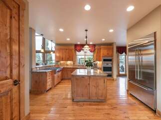 Experience luxury in this spacious kitchen featuring custom wood cabinetry and granite countertops.