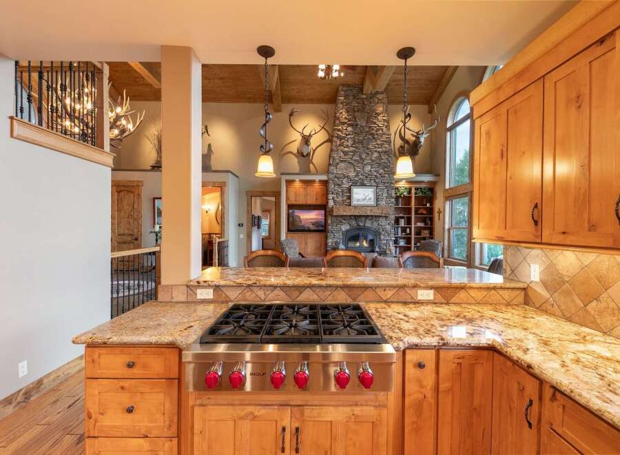 Experience rustic luxury in this stunning kitchen, featuring a professional-grade Wolf gas range and granite countertops.