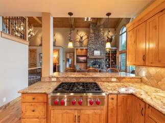 Experience rustic luxury in this stunning kitchen, featuring a professional-grade Wolf gas range and granite countertops.