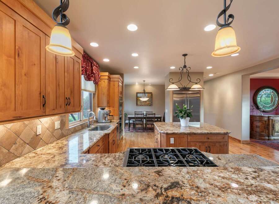 Experience luxury in this spacious kitchen featuring custom wood cabinetry and stunning granite countertops.